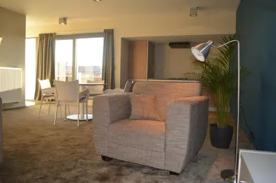 a living room with a chair and a table at Appartroom Hasselt in Hasselt