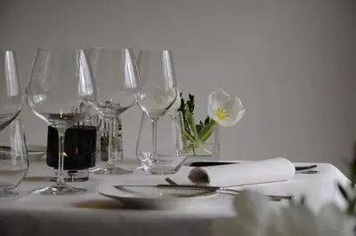 a table with wine glasses and a napkin on it at Hotel Restaurant De Kommel in Voeren