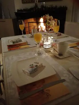 a table with a plate with a cake and wine glasses at La Rose in Overpelt