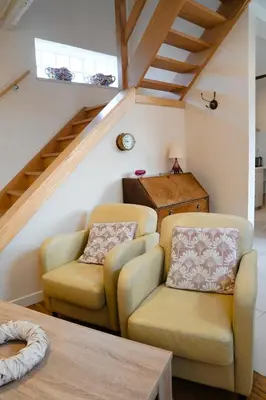 a living room with two chairs and a table at De Koetsier in Lanaken