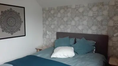 a bed with blue and white pillows in a bedroom at B&B De Laak in Bilzen