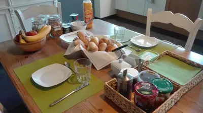 a table with a basket of bread and fruit on it at B&B De Laak in Bilzen
