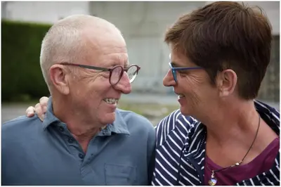 an older man and a woman are smiling at B&B De Laak in Bilzen