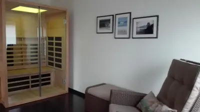 a living room with a glass door and a chair at B&B De Laak in Bilzen