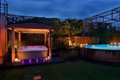 a backyard with a hot tub and a gazebo at Tuinhotel in Lommel