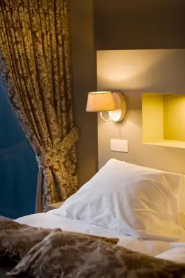 a bedroom with a bed and a lamp and a curtain at Tuinhotel in Lommel