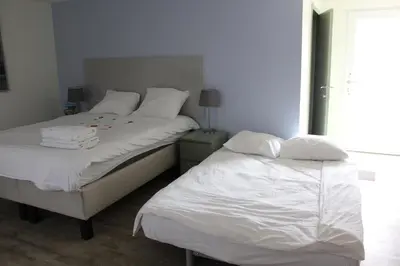a bedroom with two beds with white sheets and a window at Logie Rotem in Dilsen-Stokkem