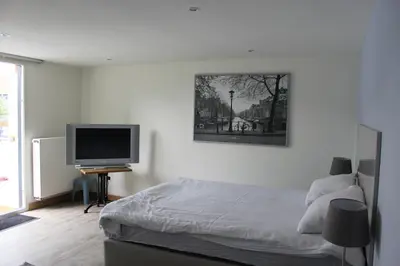 a bedroom with a bed and a flat screen tv at Logie Rotem in Dilsen-Stokkem