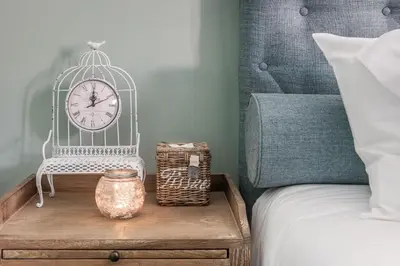 a bedroom with a bed and a clock on a table at Villa Copis in Borgloon
