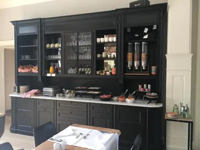 a kitchen with black cabinets and a table at Villa Copis in Borgloon