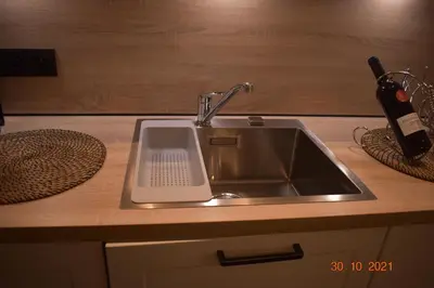 a kitchen sink with a bottle of wine next to it at Hengelhoef vakantieverblijf DEN 5 in Houthalen-Helchteren