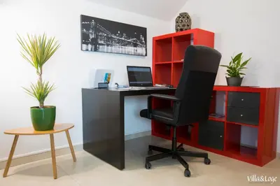 an office with a desk with a computer and red shelves at Villa&Loge in Lontzen