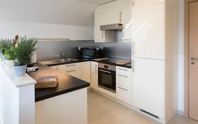 a kitchen with white cabinets and a white refrigerator at Villa&Loge in Lontzen
