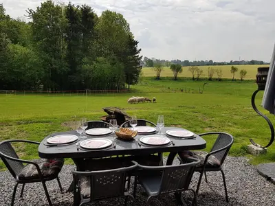 a table with plates and glasses on it in a field at Villa&Loge in Lontzen