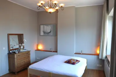 a bedroom with a bed and a dresser and a mirror at W'allons nous dormir in Liège