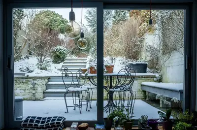 a patio with a table and chairs in the snow at W'allons nous dormir in Liège