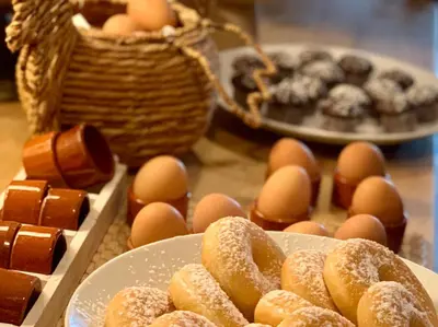 a table topped with plates of donuts and eggs at Hotel Au Nom De Dieu in Dilsen-Stokkem