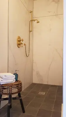 a bathroom with a shower and a table with towels at Hotel Au Nom De Dieu in Dilsen-Stokkem