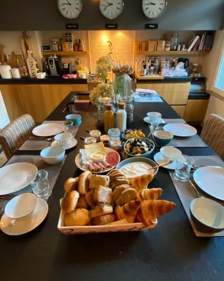 a table with a tray of bread and other food on it at Hasselt City Garden Duplex in Hasselt