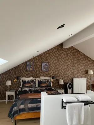 a bedroom with a bed and a wall with wallpaper at Hotel Des Ardennes in Verviers