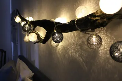 a group of lights hanging from a tree branch at (La parenthese) in Hombourg