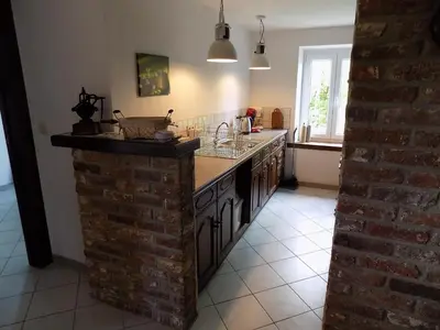 a kitchen with a brick wall and a counter top at (La parenthese) in Hombourg