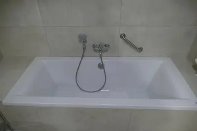 a bath tub with a shower head on top of it at Hotel Monte Cristo in Hoeselt