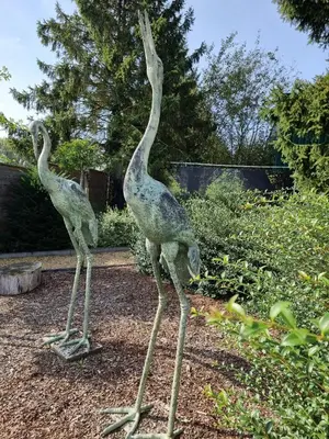 two statues of giraffes standing in a garden at Hotel Monte Cristo in Hoeselt