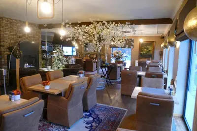 a restaurant with tables and chairs in a room at Hotel Monte Cristo in Hoeselt