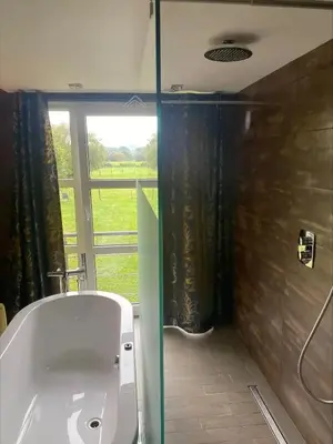 a bathroom with a sink and a shower with a window at Hotel L'Ami du Chambertin in Thimister
