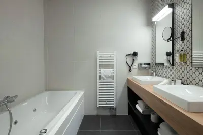 a white bathroom with a tub and a sink at Martin's Rentmeesterij in Bilzen