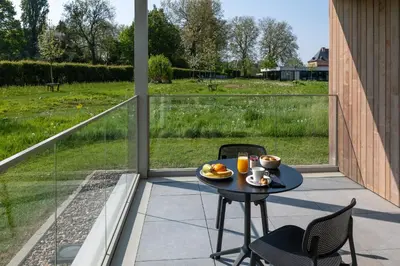 a table on a patio with a view of a field at Martin's Rentmeesterij in Bilzen