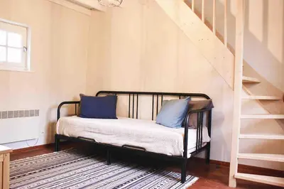 a bed with blue pillows in a room with a staircase at De Hoog Weyen in Halen