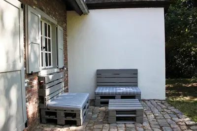 two benches sitting on a patio next to a building at De Hoog Weyen in Halen