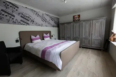 a bedroom with a large bed with pink and purple pillows at Bed 'n Blues **** in Halen