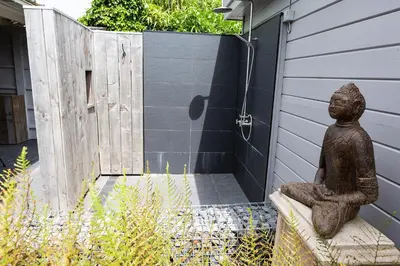 a statue sitting on a bench in front of a door at Bed 'n Blues **** in Halen