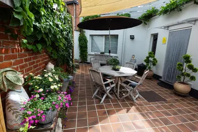 a patio with a table with an umbrella and flowers at Bed 'n Blues **** in Halen