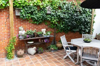 a patio with a table and some plants and a brick wall at Bed 'n Blues **** in Halen