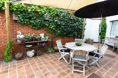 a patio with a table and chairs and an umbrella at Bed 'n Blues **** in Halen