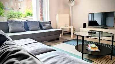 a living room with a couch and a tv at Augustins in Liège