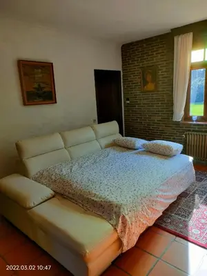 a bedroom with a large bed and a couch at De Stille Weier in Genk