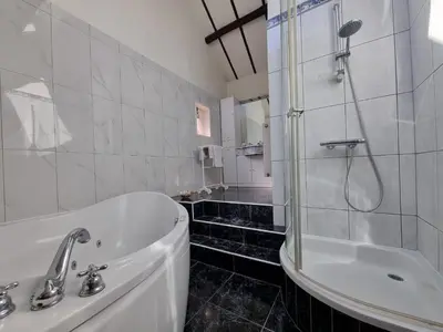 a bathroom with a tub and a shower and a sink at De Stille Weier in Genk