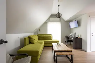 a living room with a green couch and a table at B&B Sasput in Hasselt