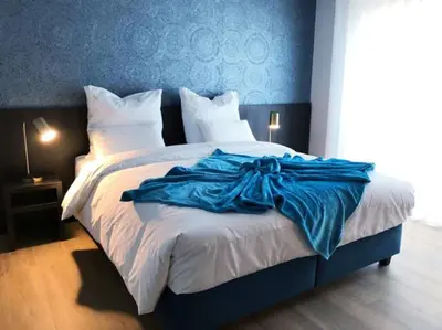 a bedroom with a large bed with a blue wall at B&B Sasput in Hasselt