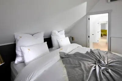 a bedroom with a white bed with white pillows at B&B Sasput in Hasselt