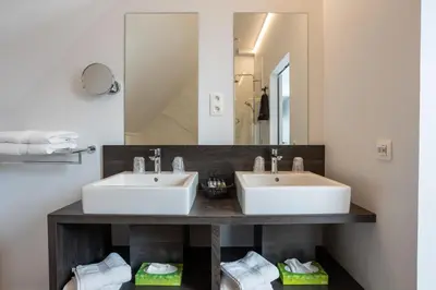 a bathroom with two sinks and a mirror at B&B Sasput in Hasselt