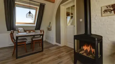 a fireplace in a room with a table and a dining room at B&B Eikenlaan 12 in Genk