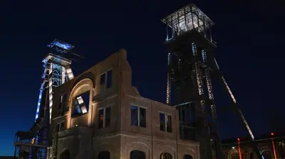 a building with a crane in the background at night at B&B Eikenlaan 12 in Genk