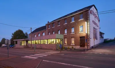 a large brick building on a street corner at Hotel Restaurant Tychon AG in Eynatten