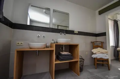 a bathroom with two sinks and a mirror at B&B De Bloesem in Hoeselt
